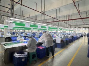 Organized toy assembly line with workers performing production and quality checks